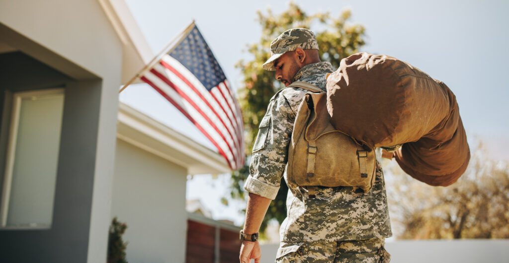 rearview of a patriotic young soldier coming back home